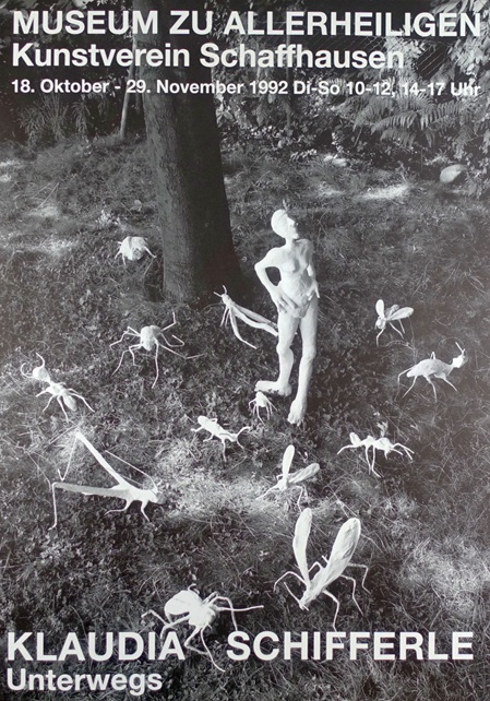 AUsstellungsplakat zu einer Ausstellung der schweizer künstlerin Claudia Schifferle mit dem Titel "Unterwegs" im Museum zu Allerheiligen, Schaffhausen, 18. Oktober bis 29. November 1992. Zeigt eine schwarz-weiss foto von verschiedenen weissen figuren, eine davon eine weibliche gestalt, viele andere sind insekten, welche auf einem Waldboden drapiert sind, im Hintergrund ein Baumstamm und büsche, farnsträucher.